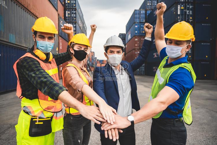 商人高管和工程师戴医用口罩和头盔同时检查工业工厂和仓库为国际航运